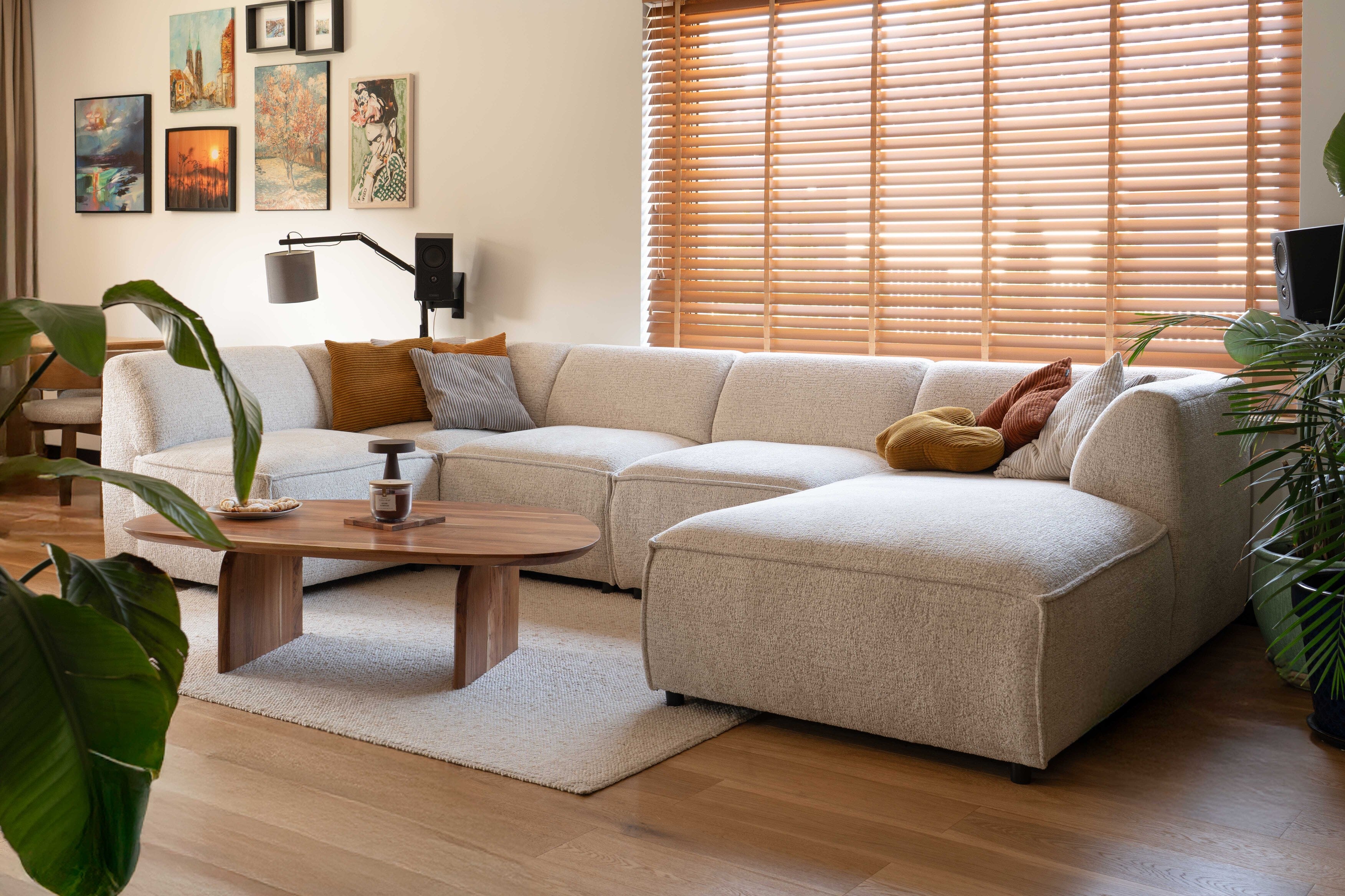 Modułowa sofa Brick w jasnym, przytulnym salonie, żółte i pomarańczowe sztruksowe poduszki
